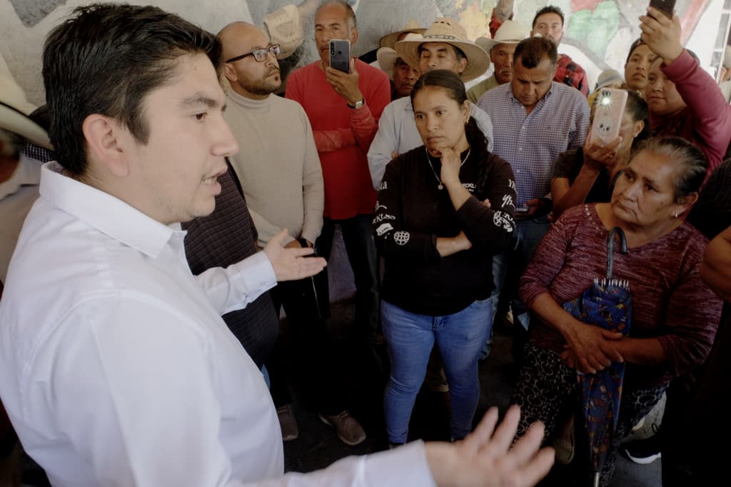 Salvador J. Vazquez Villa explica un punto a vecinas y vecinos reunidos bajo techo.