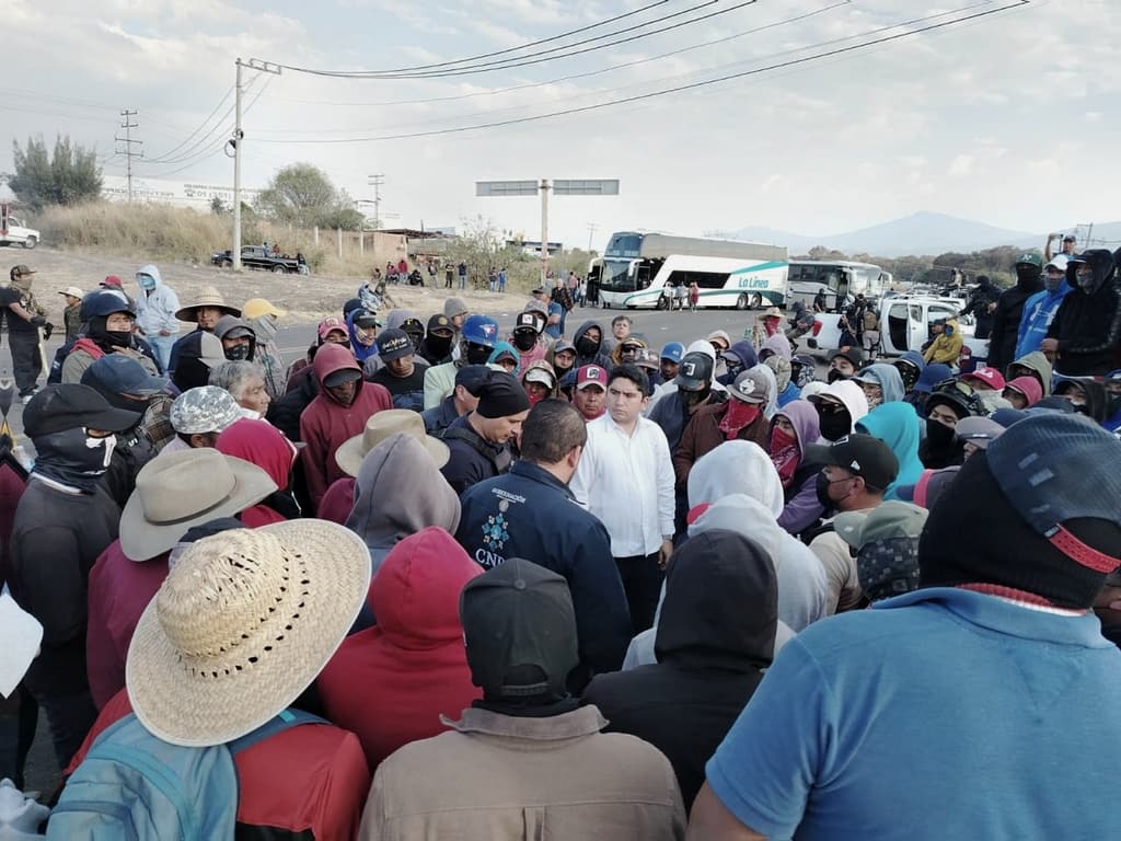 Salvador J. Vazquez Villa, al centro, dialoga con decenas de personas reunidas sobre la carretera.