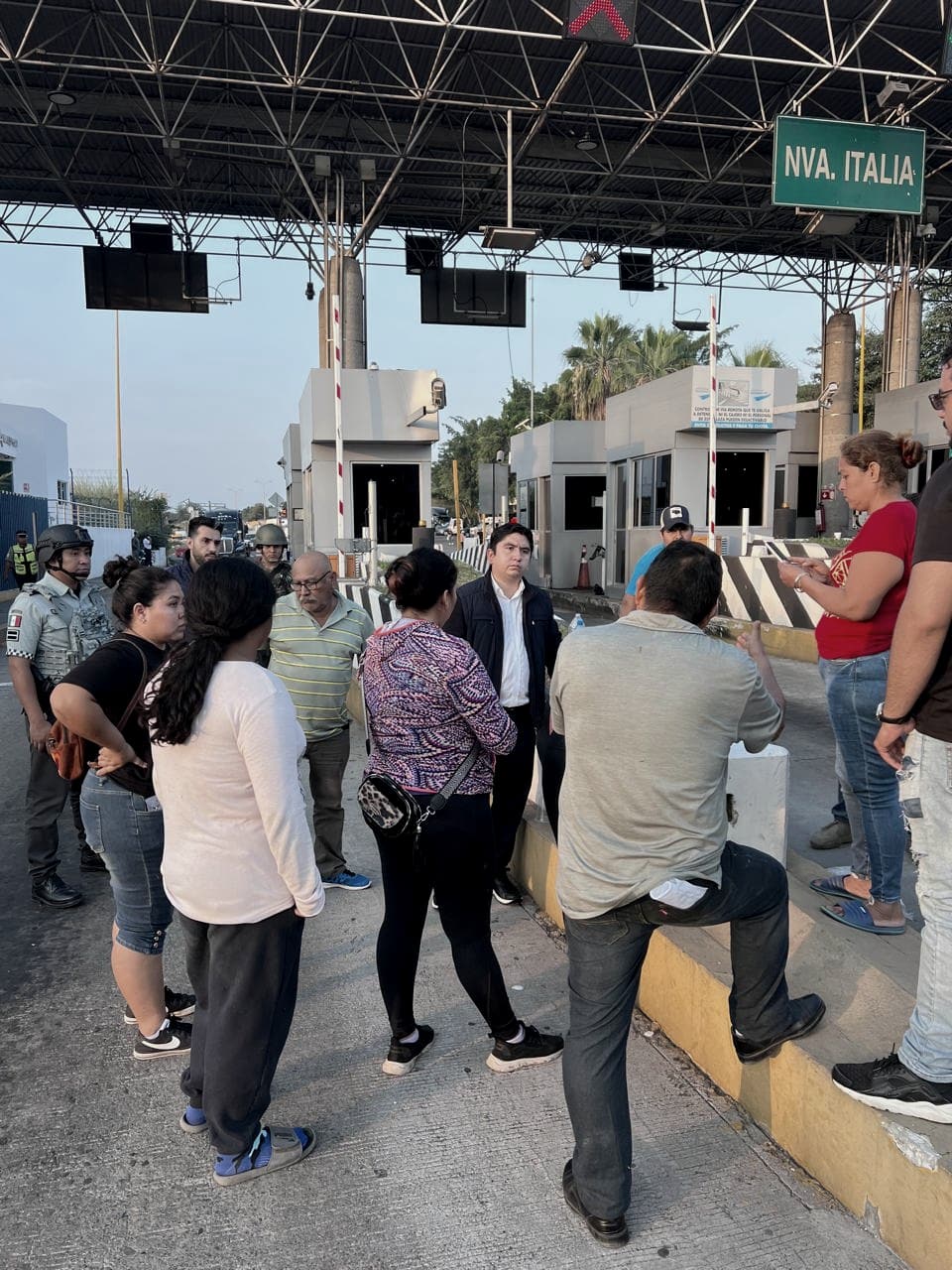 Salvador J. Vazquez Villa conversa con un grupo de personas en la plaza de cobro de Nueva Italia.