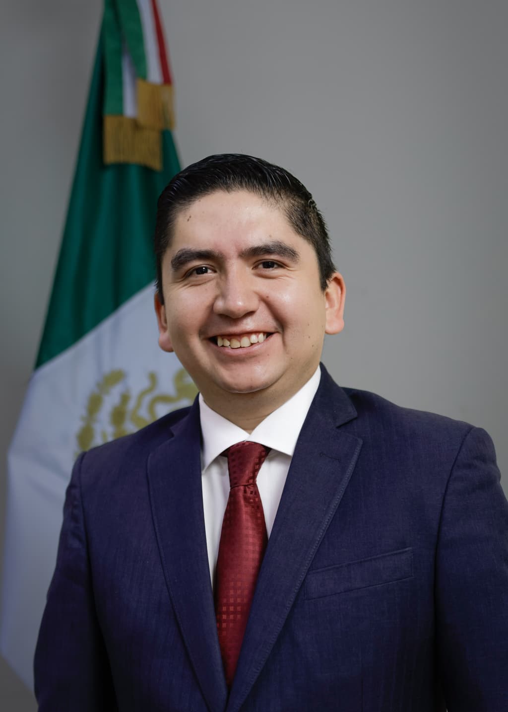 Retrato formal de Salvador J. Vazquez Villa con traje azul marino, camisa blanca y corbata roja.